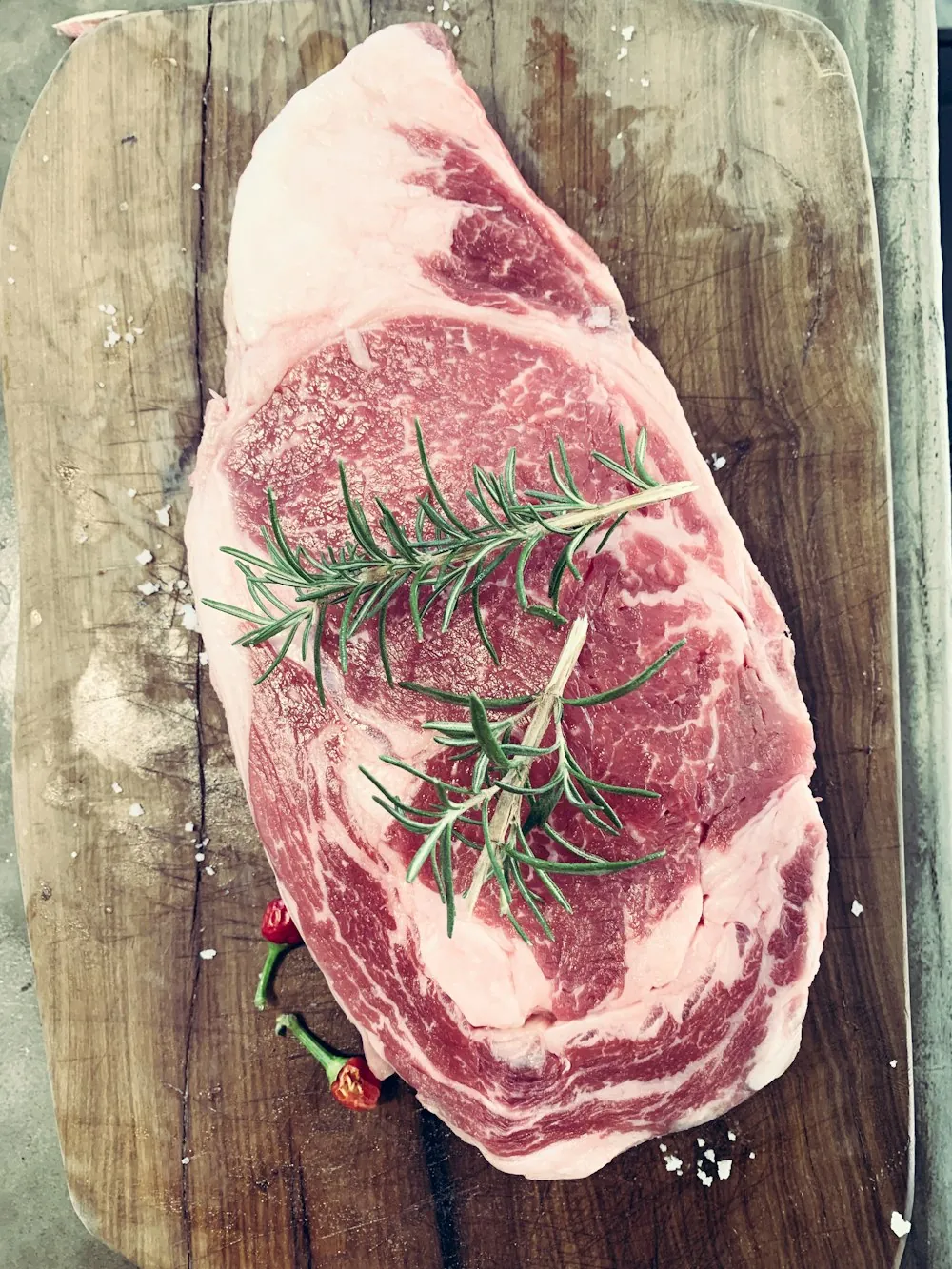 Marbled ribeye steak on a butcher block